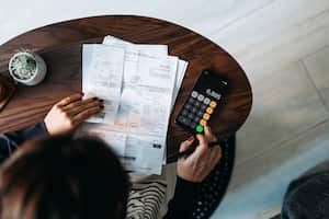 Foto de referencia de facturas en medio de una persona haciendo cálculos