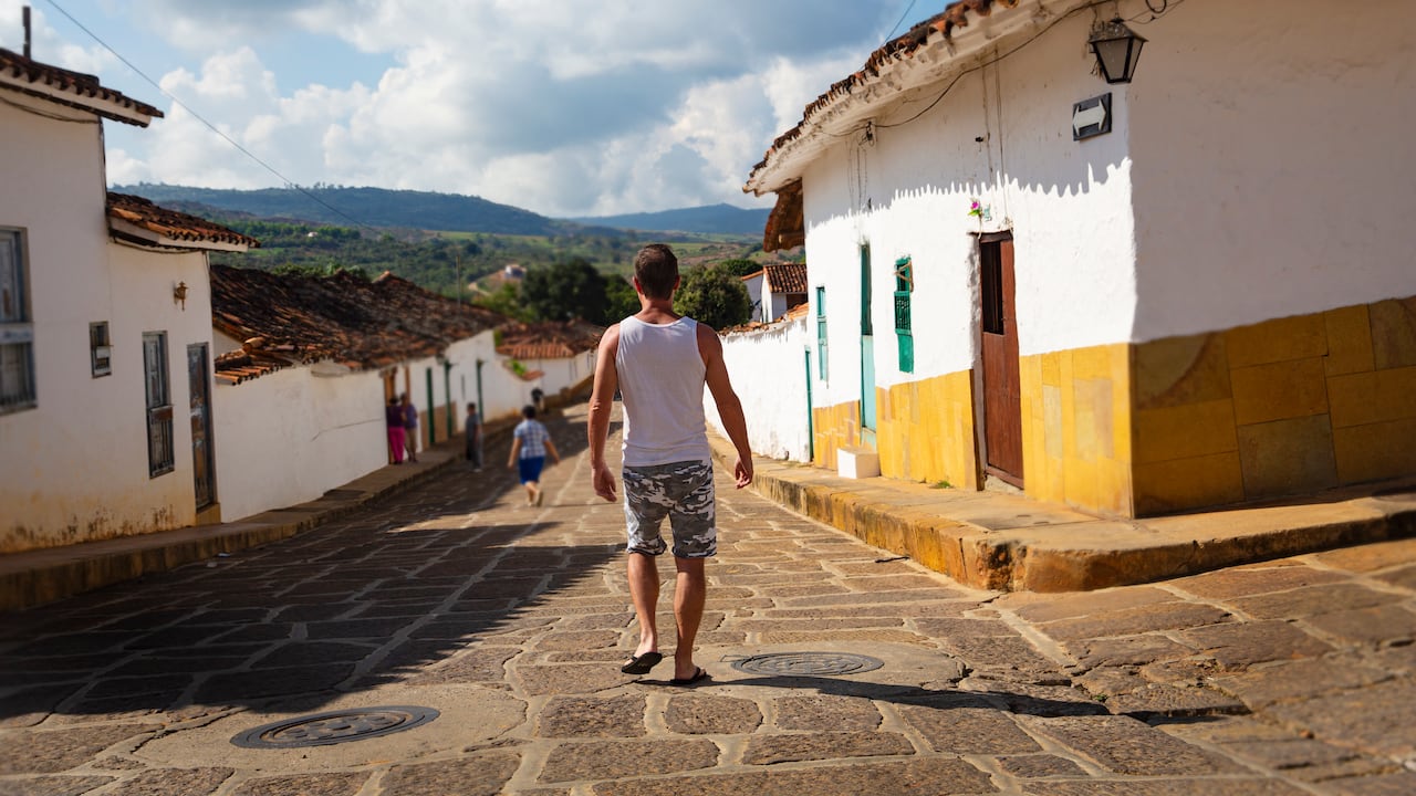 Turista caminando por una calle en la bonita y popular ciudad turística de Barichara, un pueblo del norte de Colombia conocido por sus calles adoquinadas y arquitectura colonial y un destino turístico muy popular.