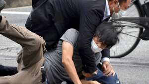 Tetsuya Yamagami, bottom, is detained near the site of gunshots in Nara Prefecture, western Japan, Friday, July 8, 2022. Former Japanese Prime Minister Shinzo Abe, a divisive arch-conservative and one of his nation's most powerful and influential figures, has died after being shot by Yamagami during a campaign speech Friday in western Japan, hospital officials said.(Katsuhiko Hirano/The Yomiuri Shimbun via AP)