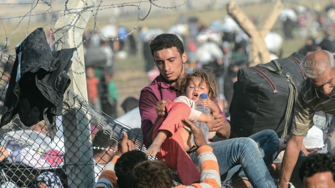 Un grupo de refugiados sirios entra a Turquía por el paso fronterizo de Sanliurfa, al suroriente del país.