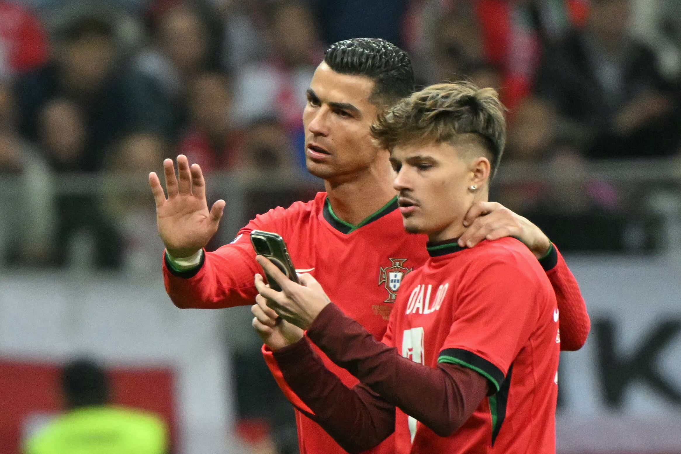 Un invasor de campo se toma selfies con el delantero de Portugal #07 Cristiano Ronaldo durante el partido de fútbol Polonia vs Portugal de la UEFA Nations League, Liga A Grupo A1 en el Estadio Nacional de Varsovia, Polonia, el 12 de octubre de 2024.