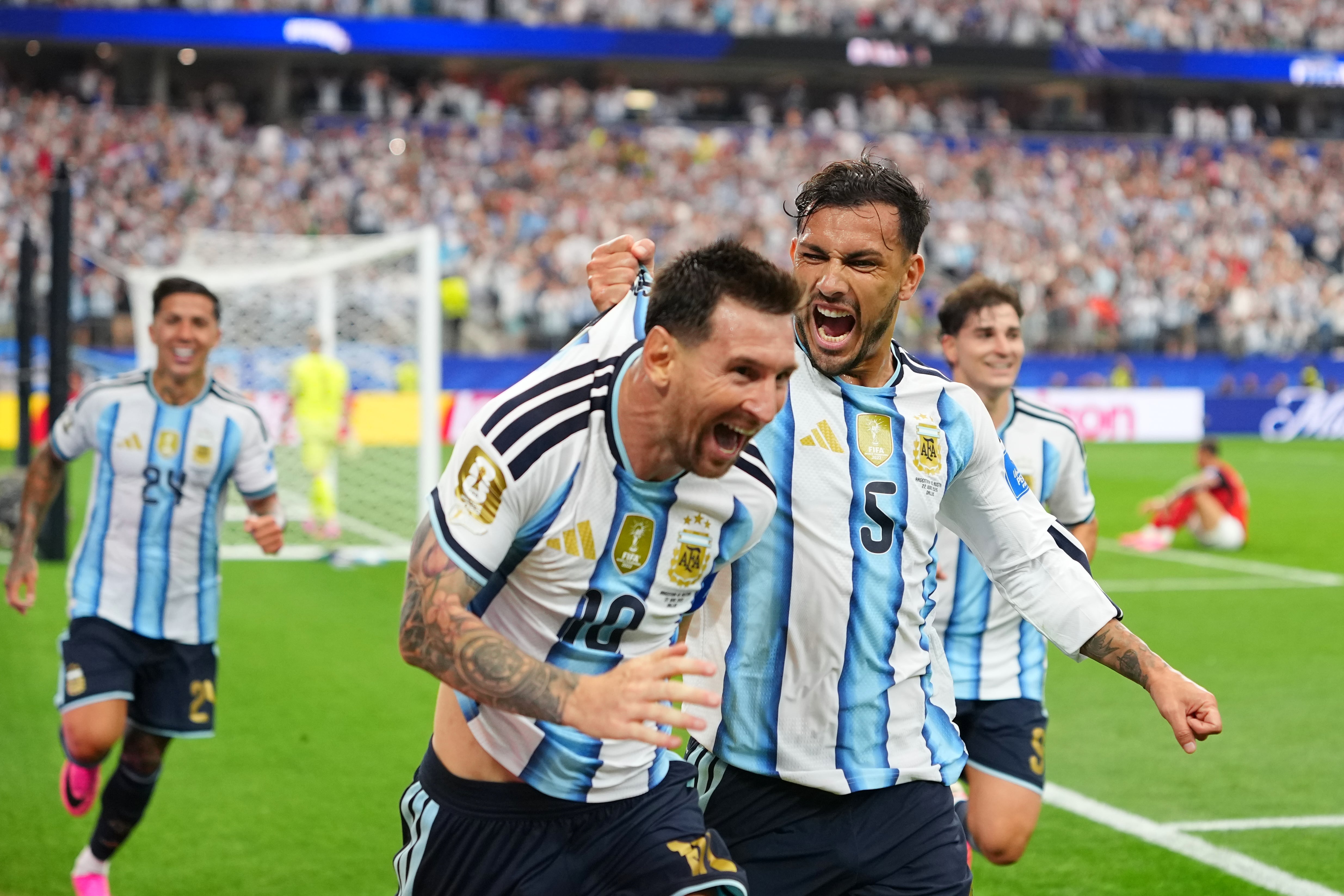 Argentina's Leandro Paredes (5) holds on to the shirt of teammate Lionel Messi celebrating after he scored their second goal during the World Cup Group J soccer match between Argentina and Austria in Arlington, Texas, near Dallas, Monday, June 22, 2026. (AP Photo/Julio Cortez)