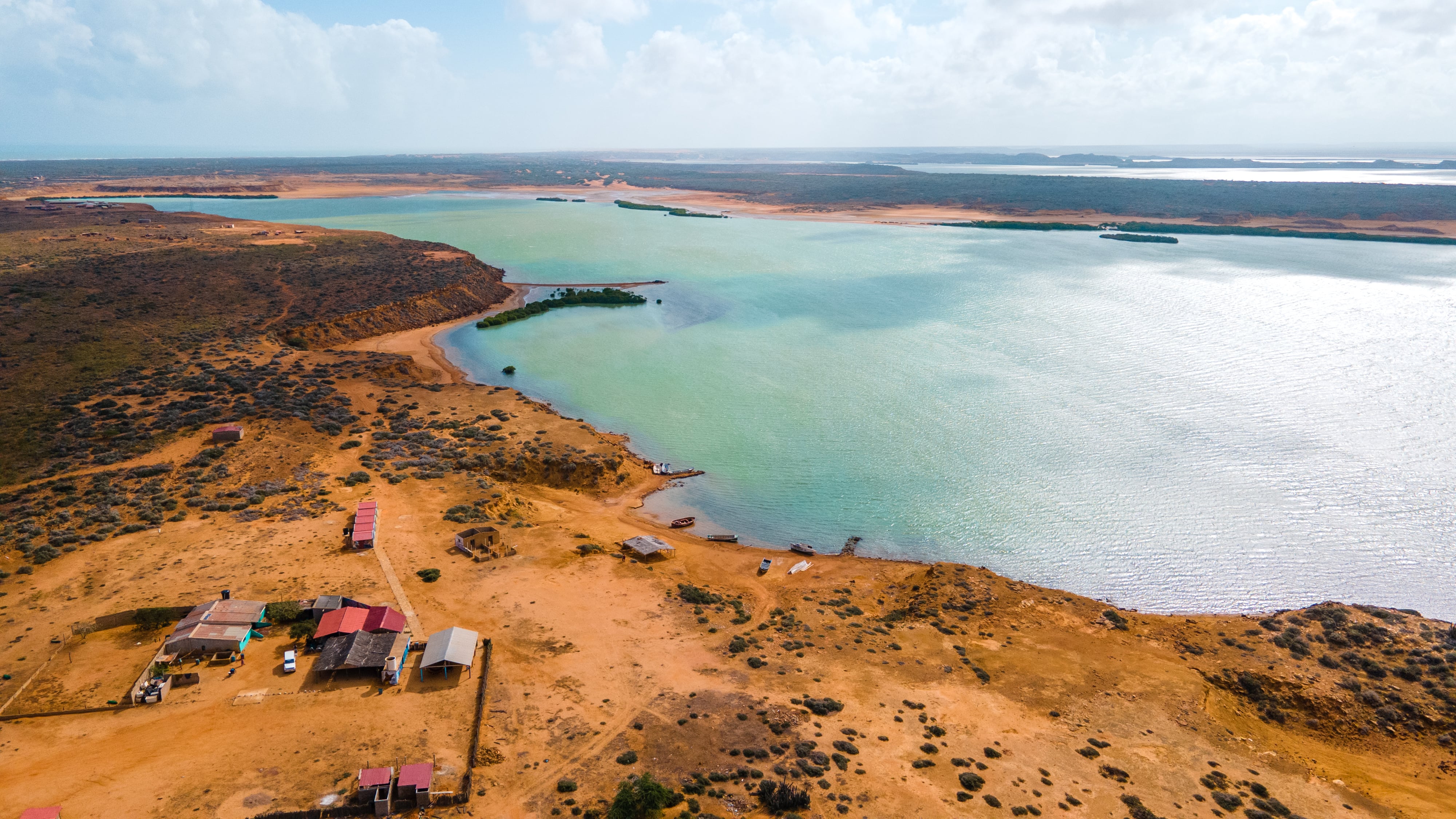 Stunning aerial landscape of La Guajira, Colombia showcasing serene water, sandy shores, and vibrant nature.