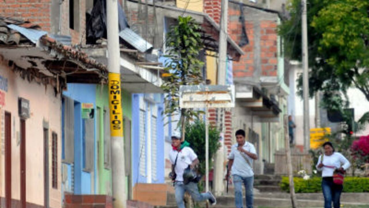 Miembros de un resguardo indígena corren para resguardarse en la población de Toribío, Cauca.