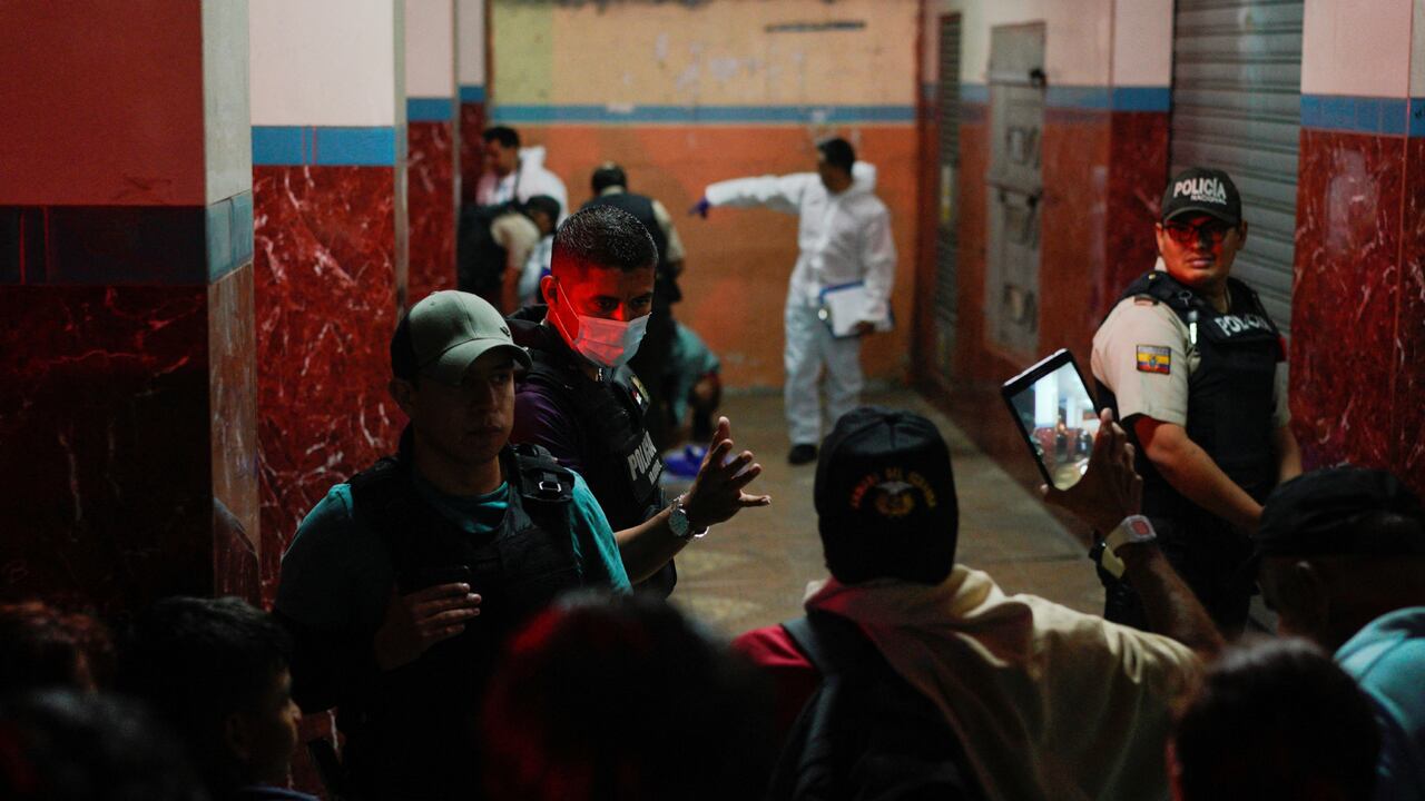 Una persona toma una foto mientras los agentes de policía investigan una escena del crimen tras la declaración del estado de emergencia y el toque de queda por parte del gobierno de Ecuador en las provincias de Guayas y Esmeraldas, después de que varios policías murieran en ataques en respuesta a los traslados de presos de las cárceles superpobladas, en Guayaquil, Ecuador 1 de noviembre de 2022. REUTERS/Santiago Arcos