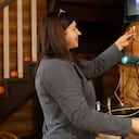 Imagen de referencia de mujer organizando los cables del televisor.