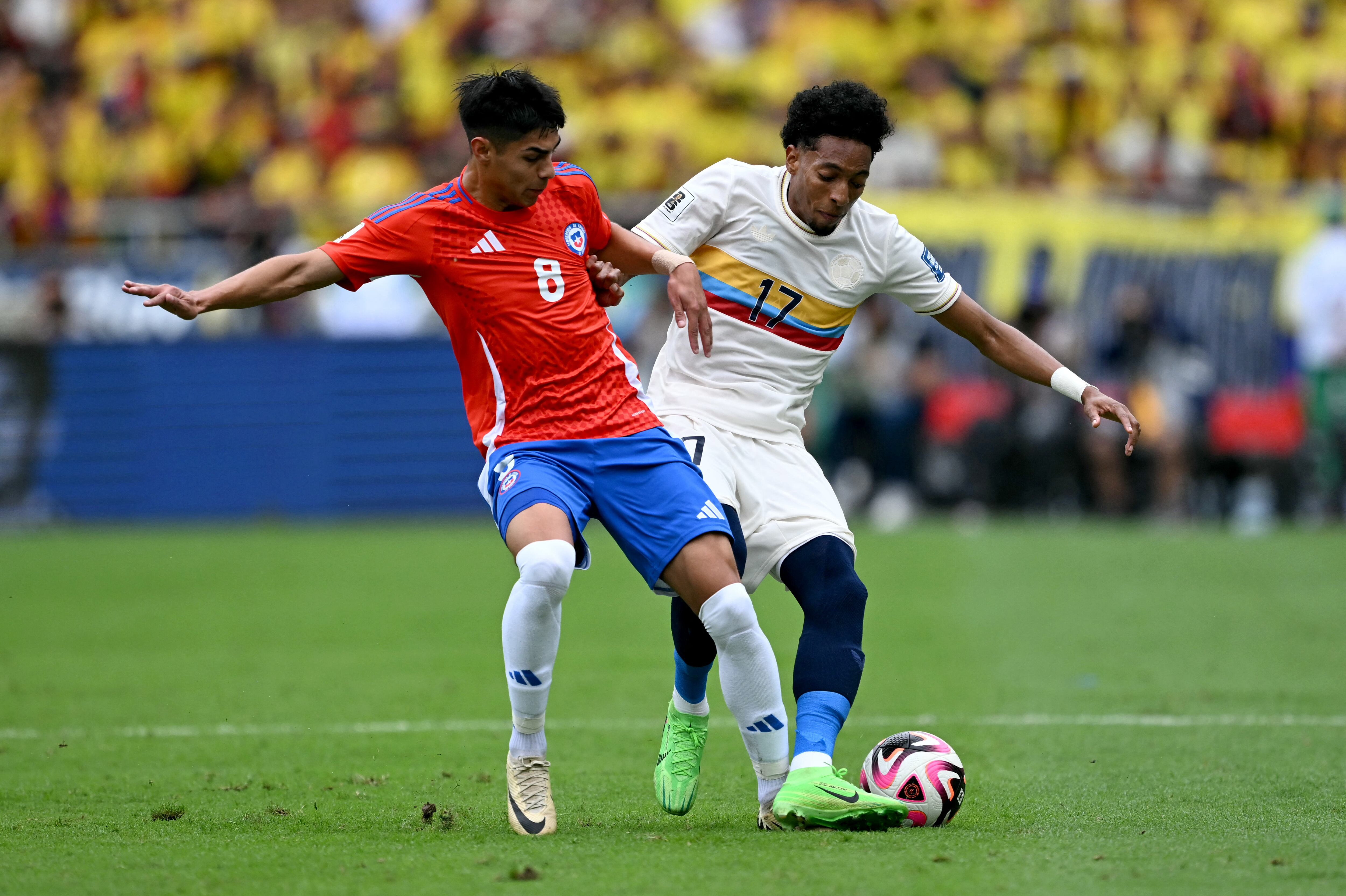 El delantero de Chile #08 Darío Osorio y el defensor de Colombia #17 Johan Mojica pelean por el balón.
