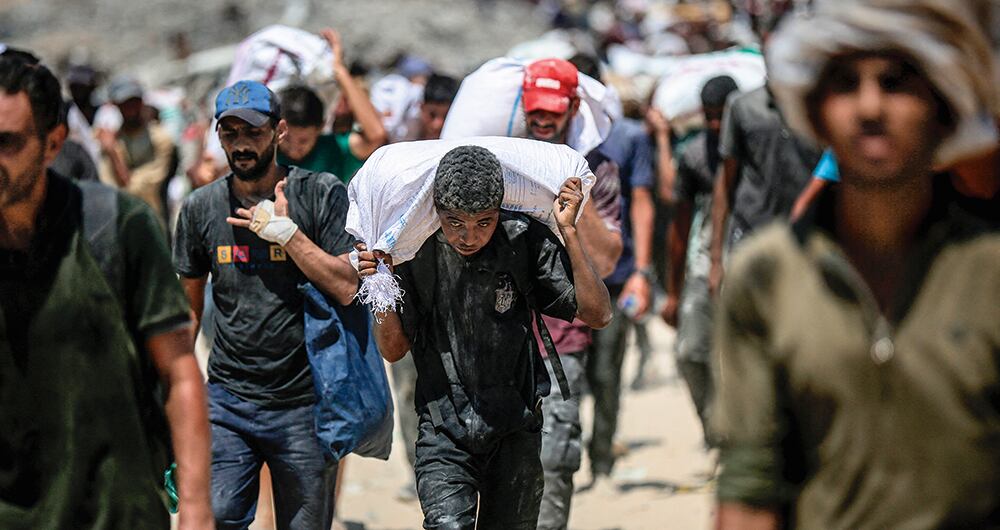 Habitantes palestinos de Gaza caminan kilómetros para recibir harina en bolsas 