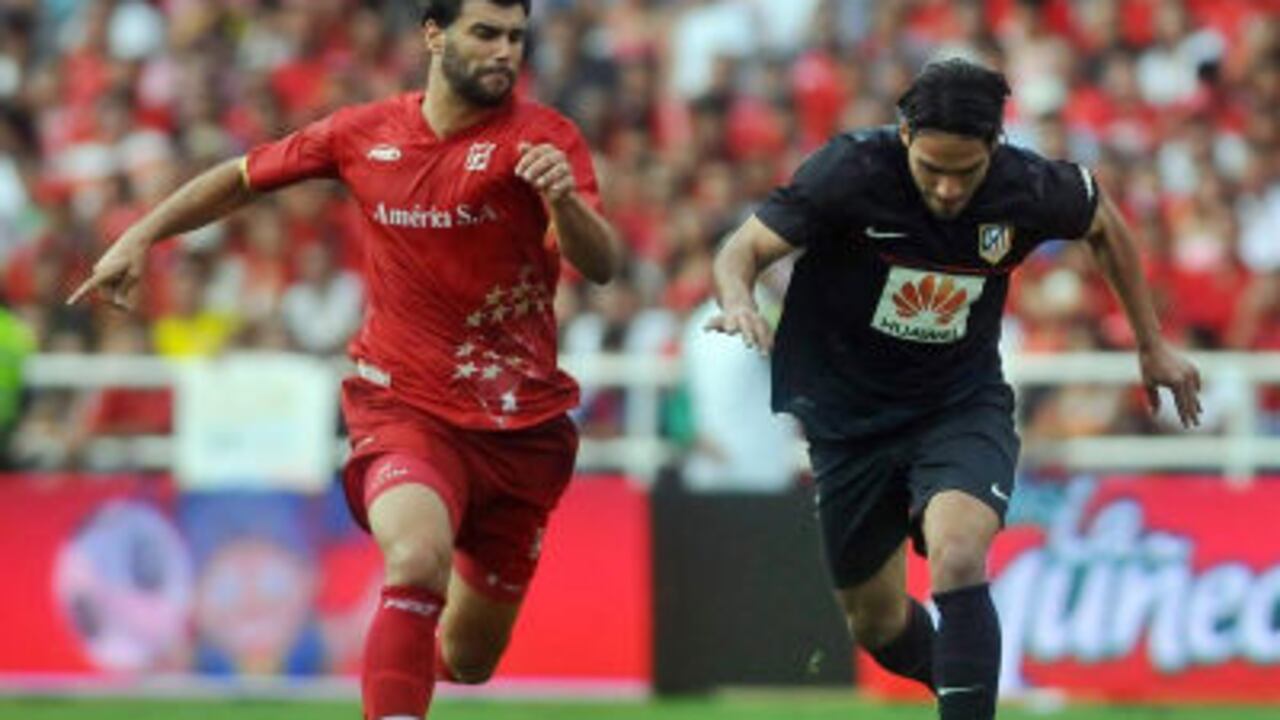 El jugador del Atlético Madrid Radamel Falcao García (d) disputa el balón con Julian Lalinde (i) de América de Cali.