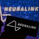 Neuralink displayed on mobile with chip brain seen on screen. On 16 April 2023 in Brussels, Belgium(Photo illustration by Jonathan Raa/NurPhoto via Getty Images)