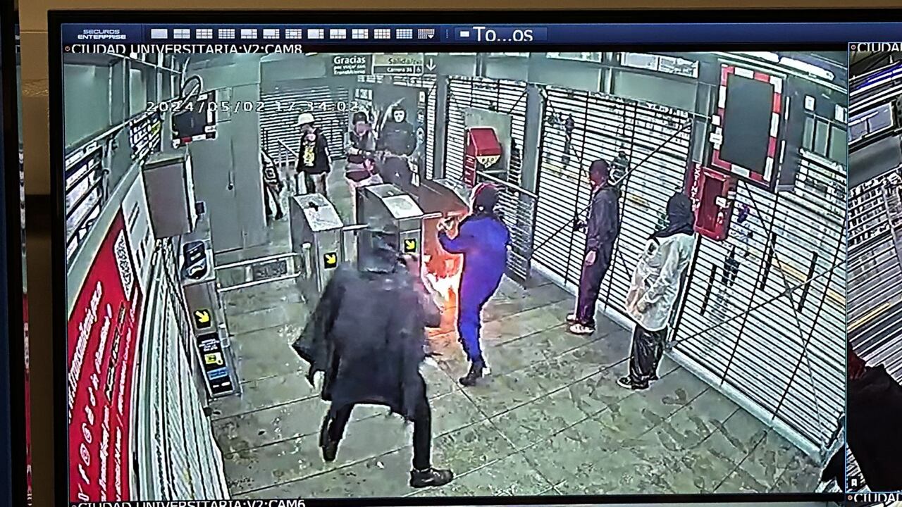 Vándalos tratando de incendiar la estación de TransMilenio de Ciudad Universitaria.