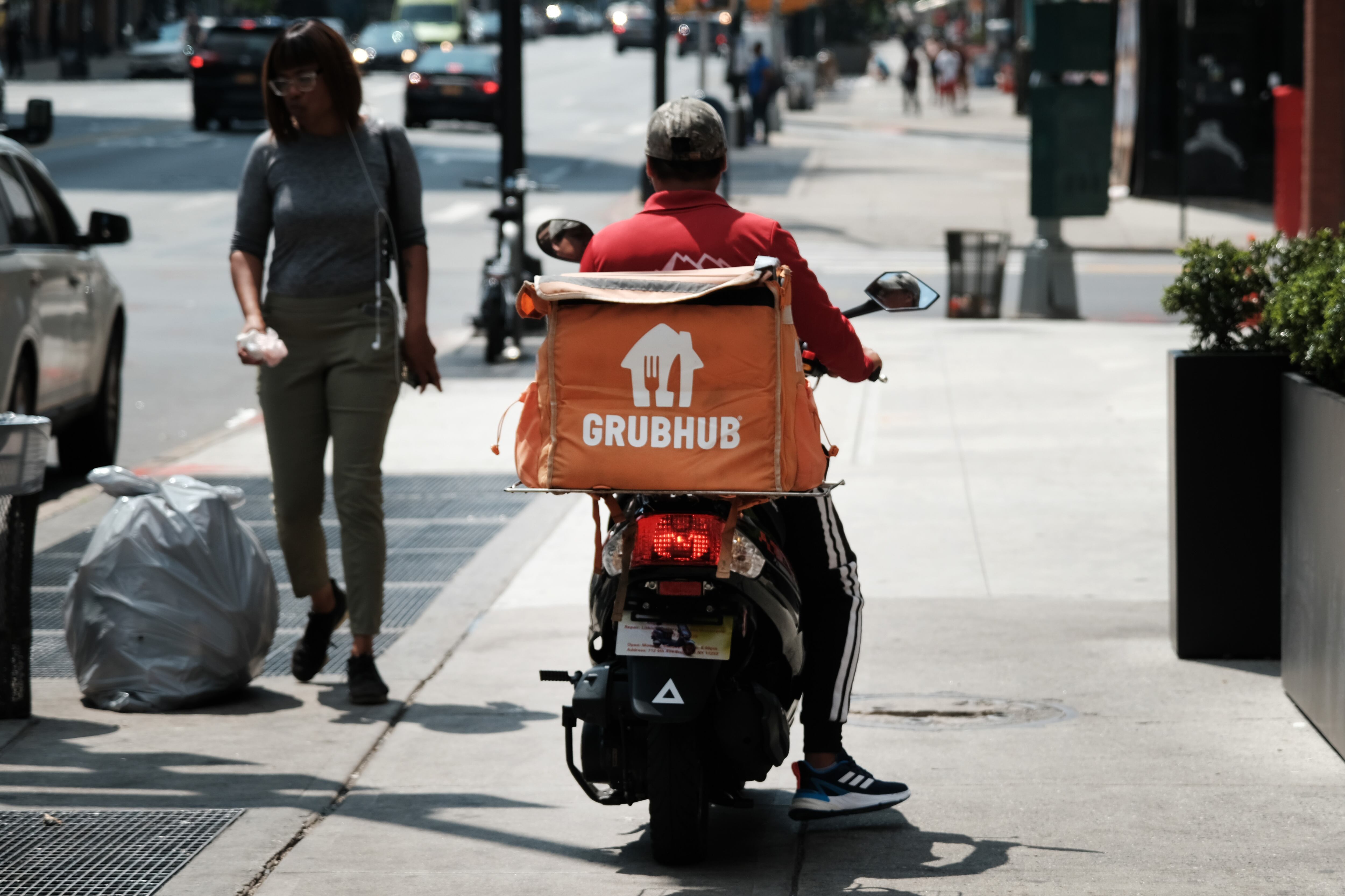 Un repartidor basado en aplicaciones espera afuera de un restaurante que utiliza entregas de aplicaciones el 7 de julio de 2023 en la ciudad de Nueva York. Uber Eats, DoorDash y GrubHub están demandando a la ciudad de Nueva York en un intento de bloquear una nueva ley que establecería requisitos de salario mínimo para los trabajadores de entrega.