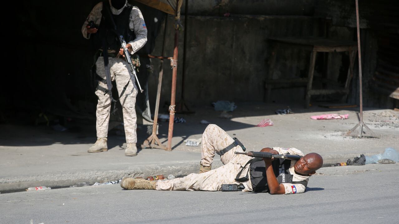 Un policía se prepara para disparar durante choques con miembros de bandas, en Puerto Príncipe, Haití, el 1 de marzo de 2024. (AP Foto/Odelyn Joseph)