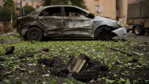 Un cohete, disparado desde el Líbano durante las horas de la noche antes del inicio del alto el fuego, se encuentra incrustado en el suelo junto a un automóvil dañado en Kiryat Shmona, en el norte de Israel, el miércoles 27 de noviembre de 2024.