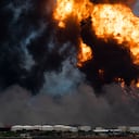 Las llamas surgen de un incendio masivo en un depósito de combustible provocado por un rayo en Matanzas, Cuba, el 8 de agosto de 2022. - Helicópteros del ejército cubano se apresuraron a contener un incendio que derribó un tercer tanque en un depósito de combustible el lunes después de arder durante días. , mientras continuaba la búsqueda de 16 bomberos desaparecidos. (Foto de YAMIL LAGE / AFP)