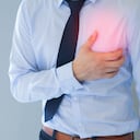 Hombre que tiene un ataque al corazón / dolor en el pecho en un fondo aislado.