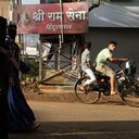 FILE- Unidentified Muslim women walk past a board displaying the name of the Hindu nationalist group Sri Ram Sena Hindustan in a residential neighborhood in Belagavi, India, Oct. 7, 2021. Police elsewhere in India have arrested a man alleged to be behind the offering for sale of prominent Muslim women through a fake online auction, in a case that has sparked anger and outrage across the country. (AP Photo/Aijaz Rahi, File)