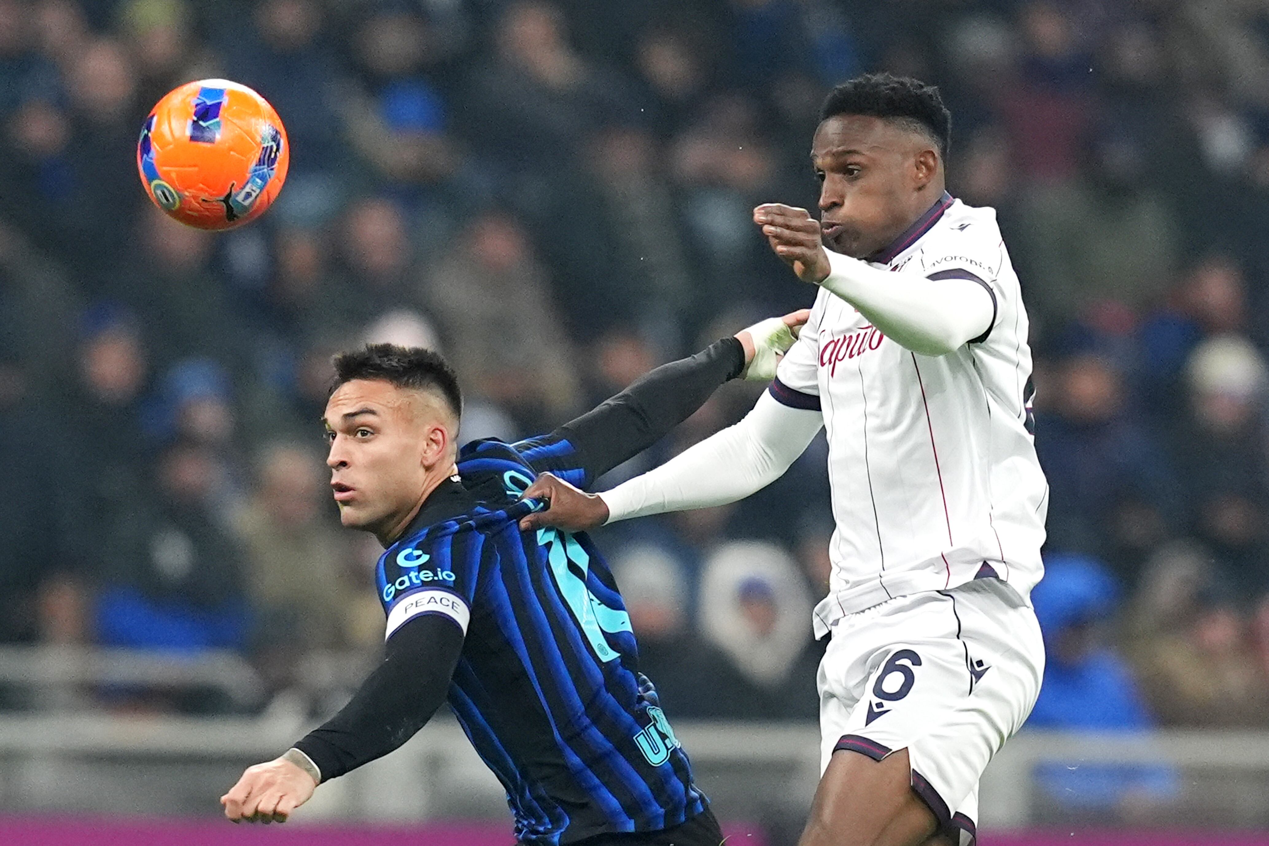 Inter Milan's Lautaro Martinez fights for the ball with Bologna's Jhon Lucumi during the Italian Serie A soccer match between Inter and Bologna in Milan, Italy, Sunday, Jan. 4, 2026. (Spada/LaPresse via AP)