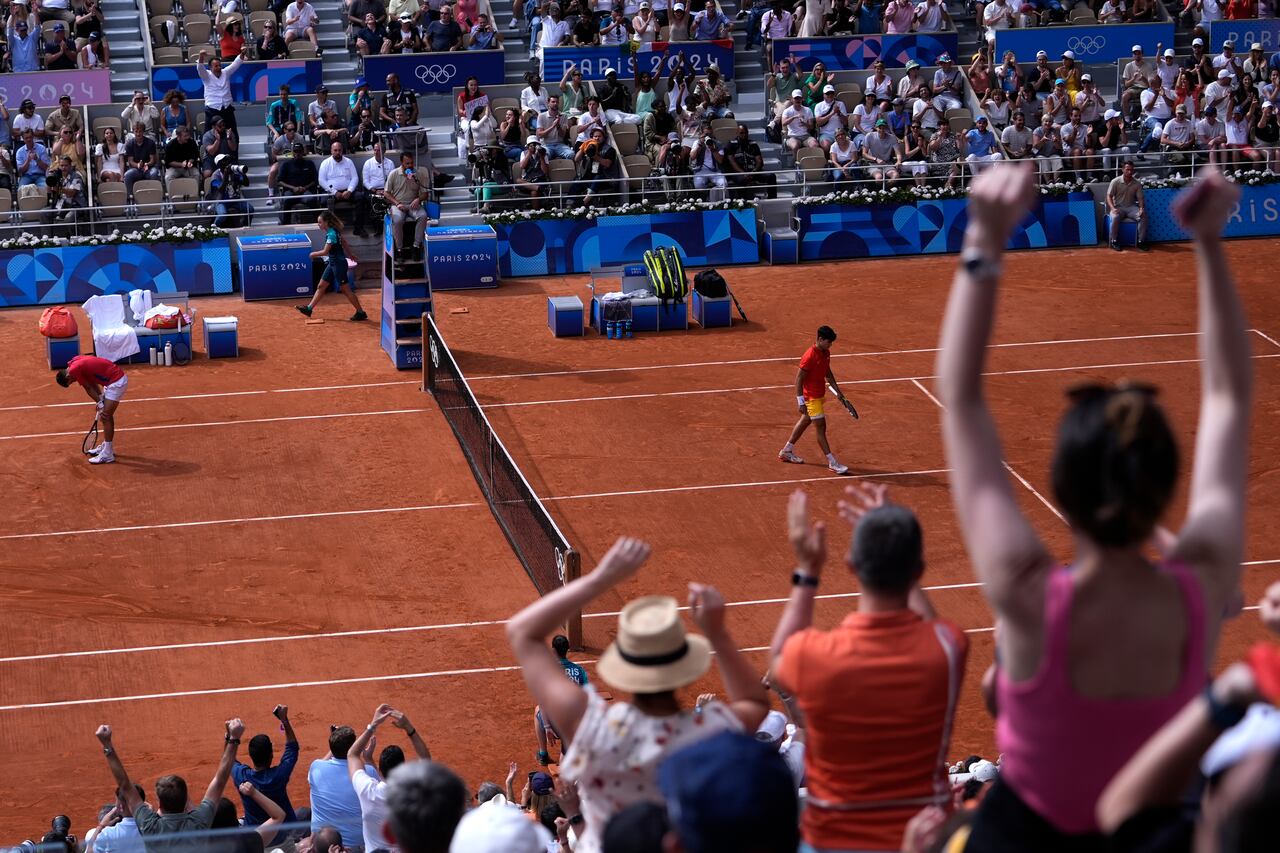 Spectators react after Spain's Carlos Alcaraz, right, won a point against Serbia's Novak Djokovic during the men's singles tennis final at the Roland Garros stadium during the 2024 Summer Olympics, Sunday, Aug. 4, 2024, in Paris, France. (AP Photo/Andy Wong)