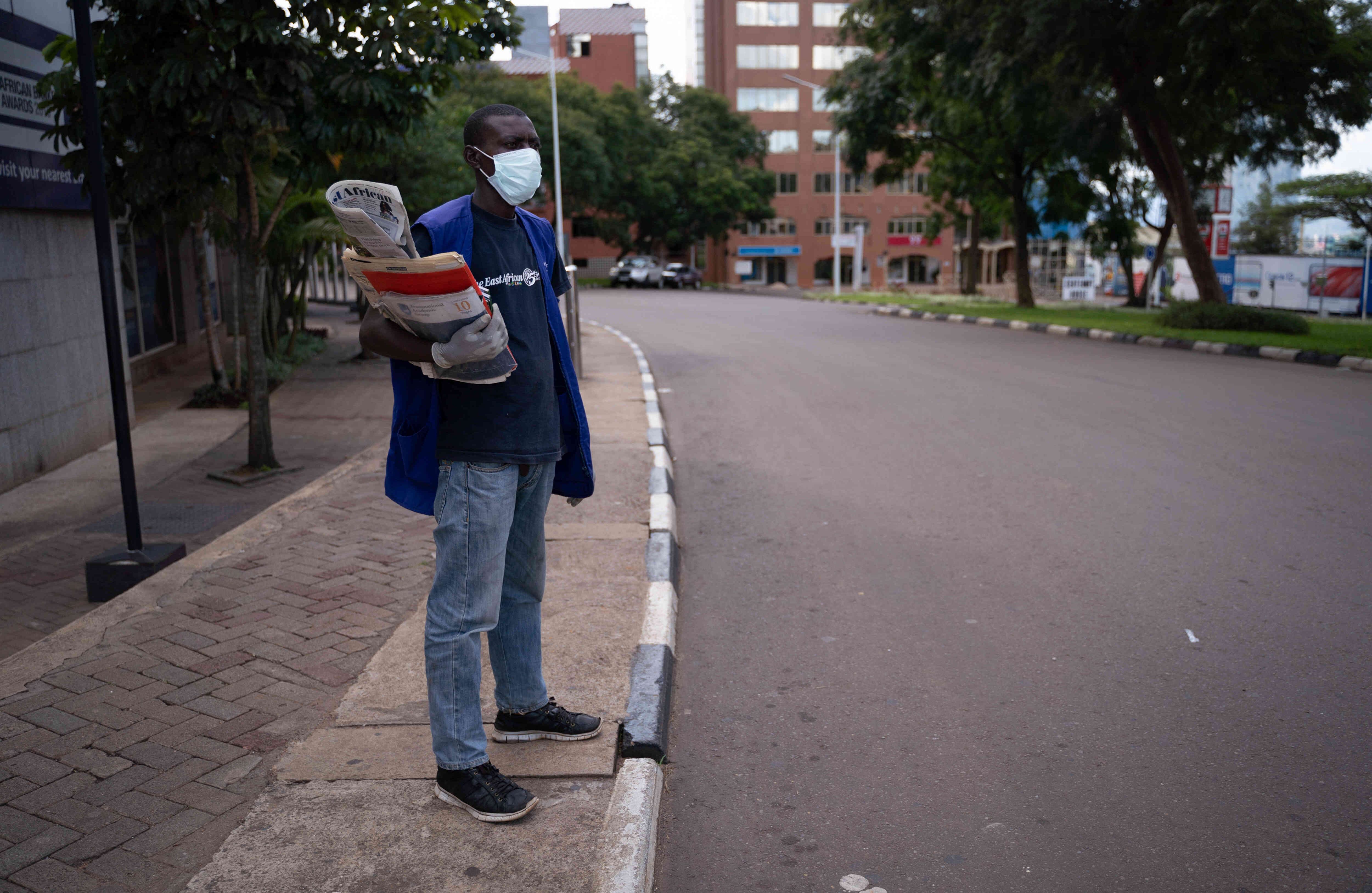 Un vendedor de periódicos usa una máscara como medida preventiva contra el coronavirus en una calle vacía en Kigali, Ruanda, después de que el gobierno suspendió todos los movimientos innecesarios durante dos semanas para frenar la propagación del virus. Los países africanos han sido los últimos afectados por la epidemia mundial de coronavirus pero, a medida que aumentan los casos, muchas naciones están tomando medidas estrictas para bloquear la enfermedad mortal. Foto: AFP.
