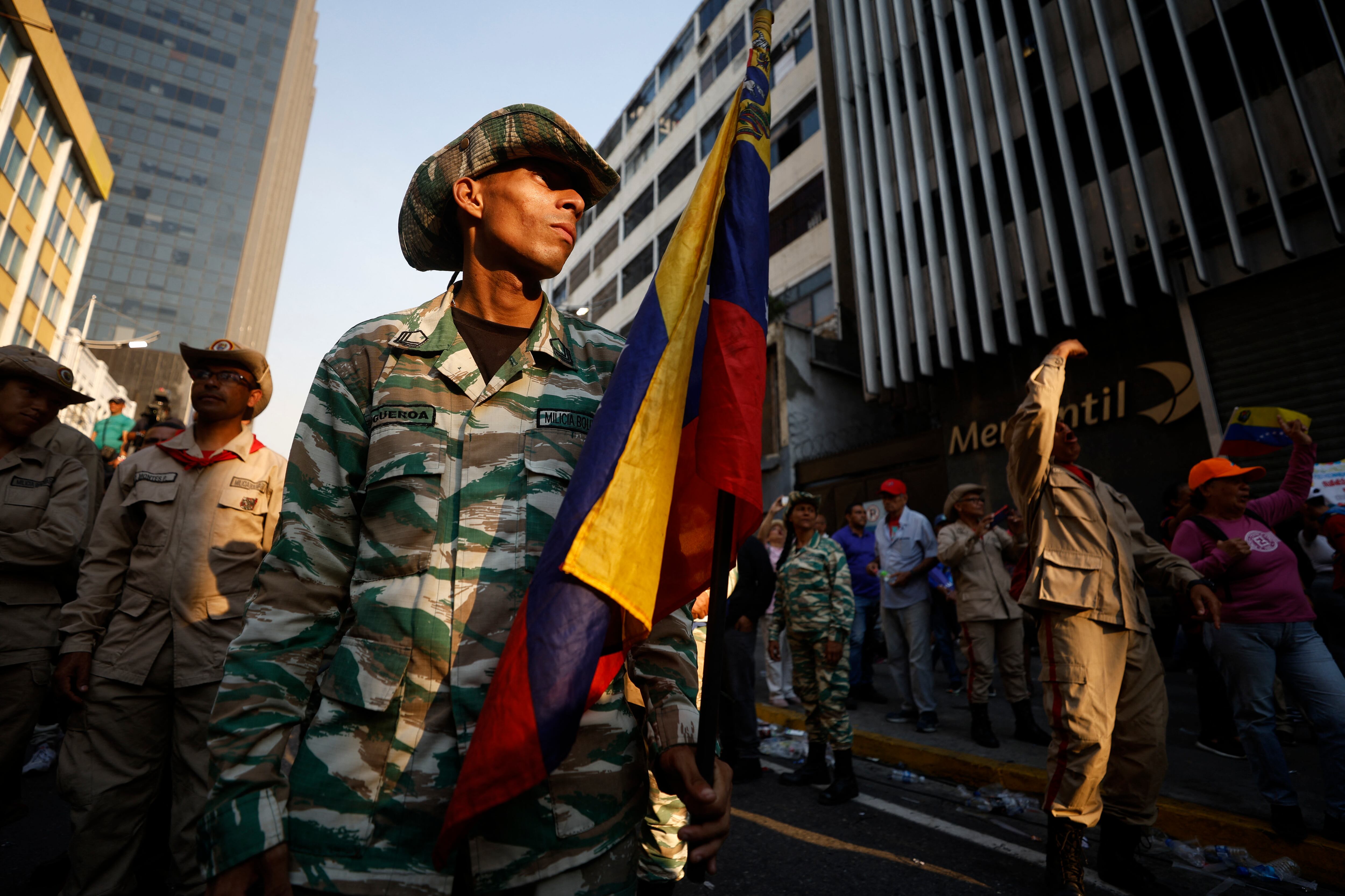 Miembros de la Milicia Nacional Bolivariana participan en una marcha en apoyo a los migrantes venezolanos deportados de Estados Unidos a El Salvador en Caracas el 25 de marzo de 2025. (Foto de Pedro MATTEY / AFP)