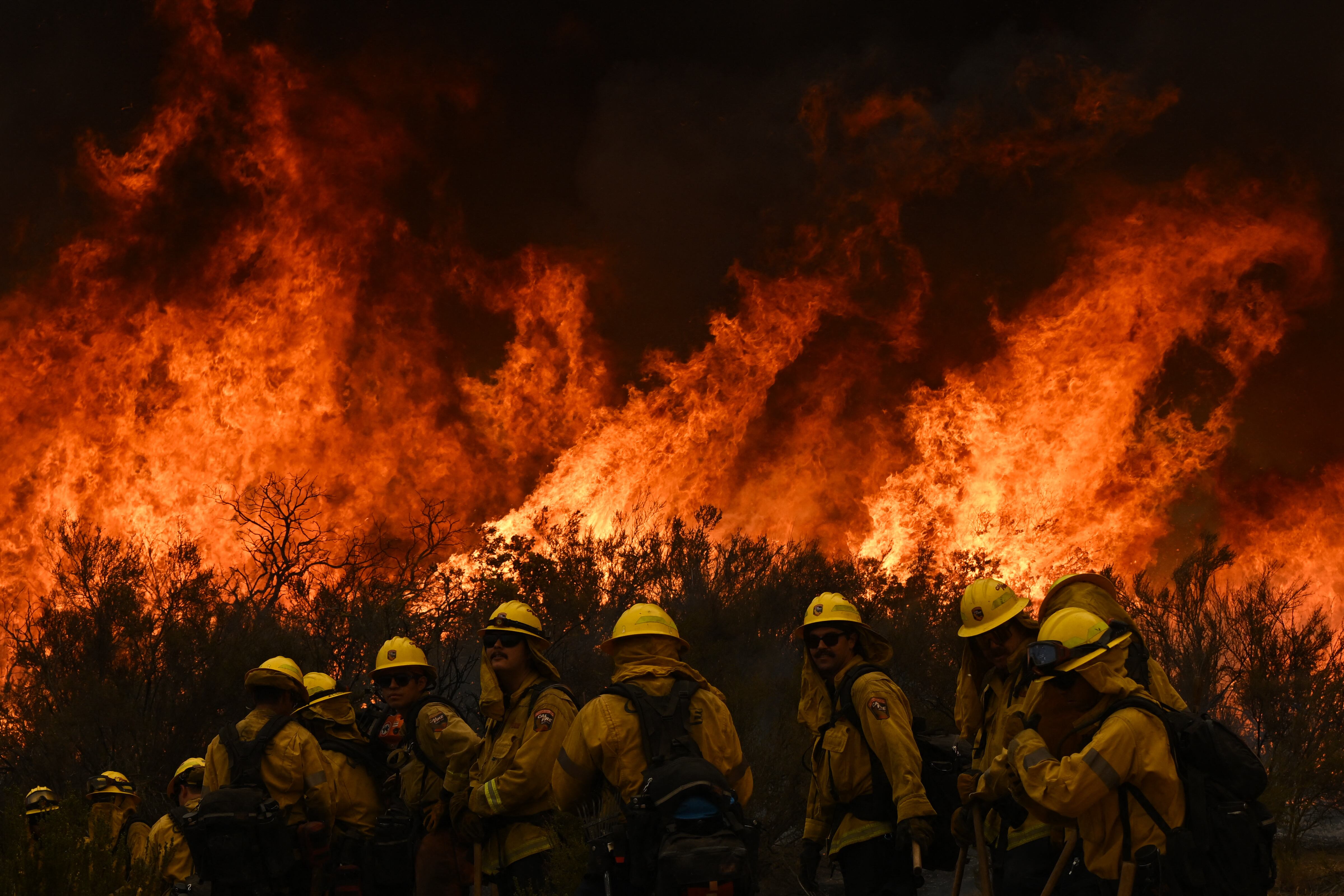 Los bomberos de CalFire se alejan del fuego para observar si hay brasas perdidas durante una operación de disparo para construir una línea para contener el incendio de Fairview cerca de Hemet, California, el 8 de septiembre de 2022. - Una ola de calor feroz que abrasa el oeste de los Estados Unidos finalmente podría comenzar a disminuir en los próximos días, dijeron los meteorólogos el 7 de septiembre, pero advirtieron sobre peligrosas condiciones de incendio a medida que los vientos aulladores azotan la región totalmente seca. (Foto de Patrick T. FALLON / AFP)