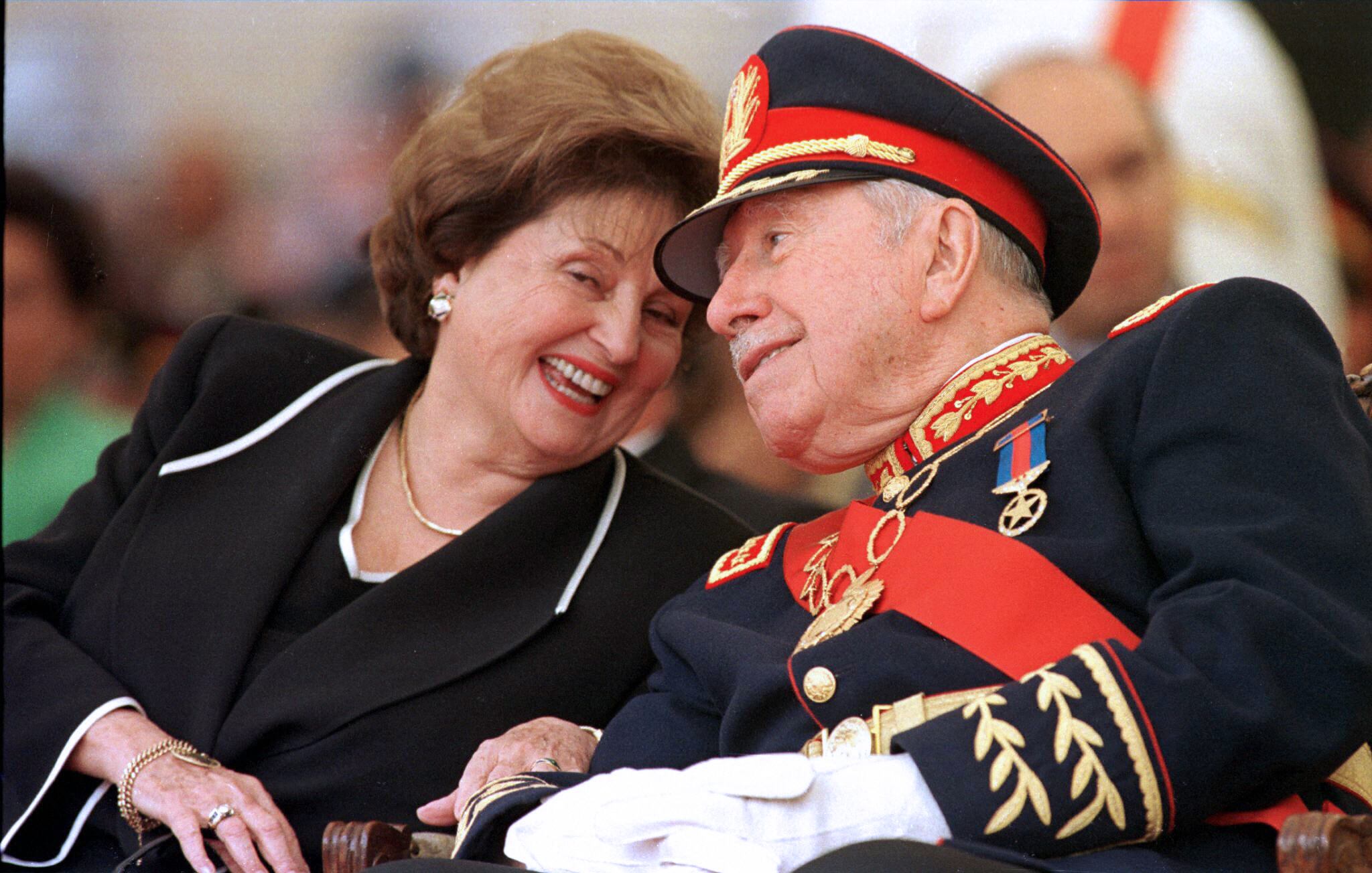 (ARCHIVOS) En esta foto de archivo tomada el 10 de marzo de 1998 el ex dictador chileno (1973-90) general Augusto Pinochet (der.) Escucha a su esposa Lucía Hiriart durante la ceremonia de retiro del mando del ejército en la Academia Militar de Santiago. - Lucía Hiriart Rodríguez, viuda del ex dictador chileno Augusto Pinochet (1973-1990), falleció el 16 de diciembre de 2021 a la edad de 99 años (Foto de Cris BOURONCLE / AFP).