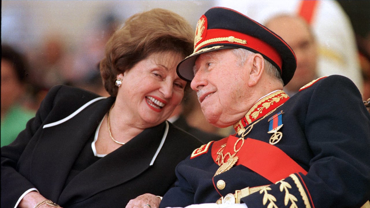 (ARCHIVOS) En esta foto de archivo tomada el 10 de marzo de 1998 el ex dictador chileno (1973-90) general Augusto Pinochet (der.) Escucha a su esposa Lucía Hiriart durante la ceremonia de retiro del mando del ejército en la Academia Militar de Santiago. - Lucía Hiriart Rodríguez, viuda del ex dictador chileno Augusto Pinochet (1973-1990), falleció el 16 de diciembre de 2021 a la edad de 99 años (Foto de Cris BOURONCLE / AFP).