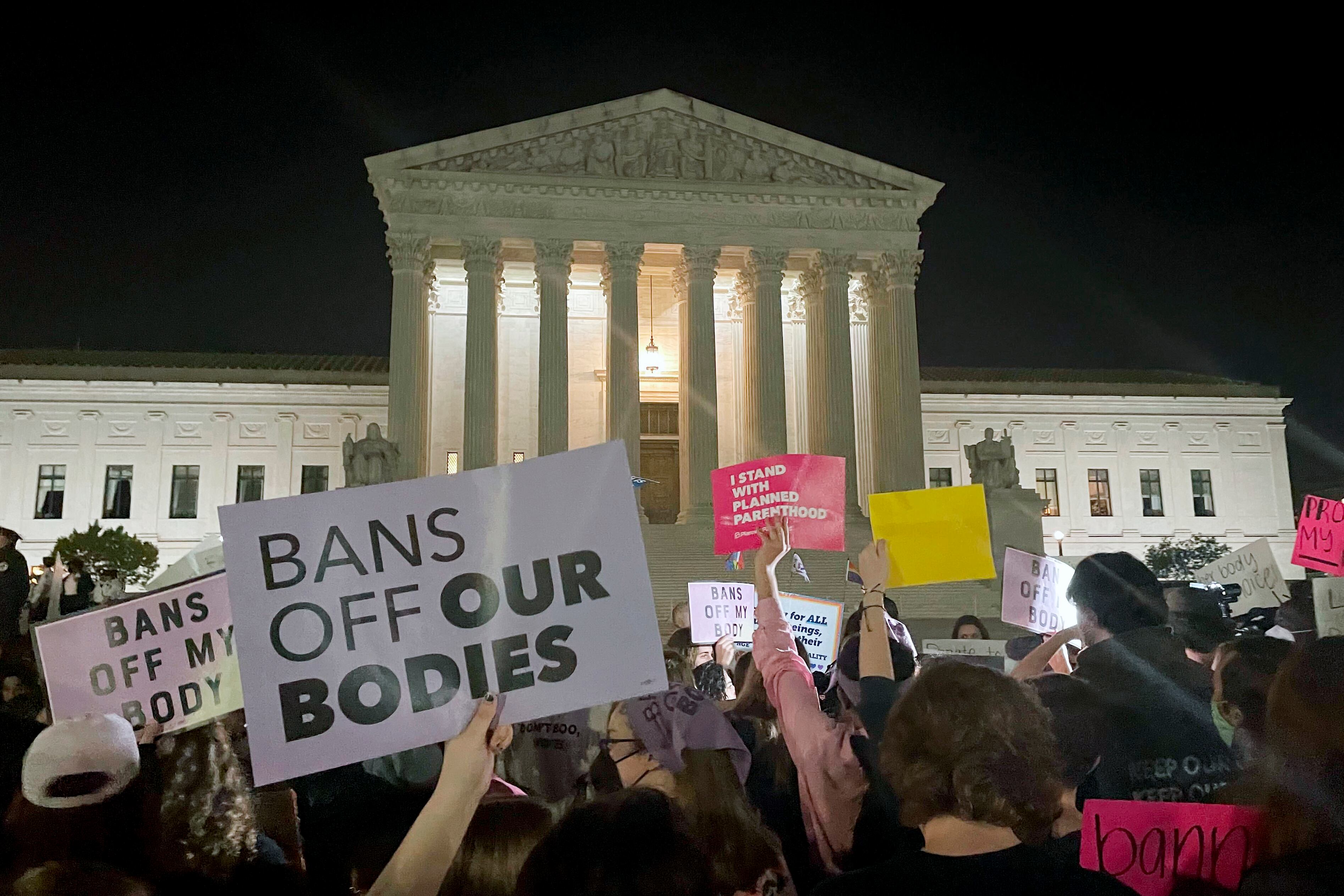 A crowd of people gather outside the Supreme Court, Monday night, May 2, 2022 in Washington. A draft opinion circulated among Supreme Court justices suggests that earlier this year a majority of them had thrown support behind overturning the 1973 case Roe v. Wade that legalized abortion nationwide, according to a report published Monday night in Politico. It’s unclear if the draft represents the court’s final word on the matter.  The Associated Press could not immediately confirm the authenticity of the draft Politico posted, which if verified marks a shocking revelation of the high court’s secretive deliberation process, particularly before a case is formally decided. (AP Photo/Anna Johnson)