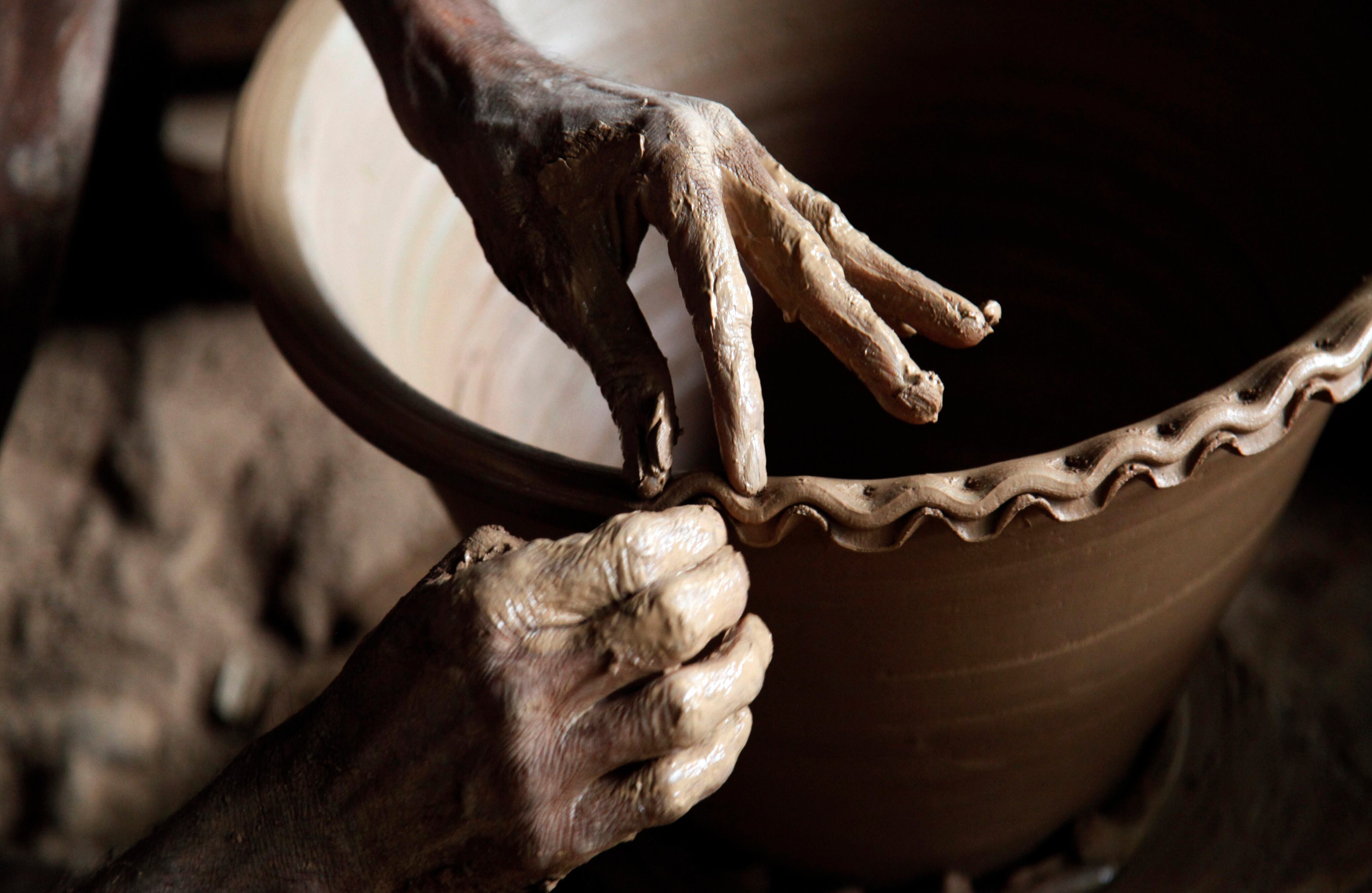 Durante generaciones la alfarería del pueblo de Twante, en Myanmar, ha sido por su calidad y valor artesanal. En la foto un hombre realiza un borde decorativo a un florero. (AP)