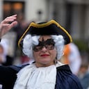 Una mujer enmascarada se sube a una góndola durante el desfile acuático, parte del Carnaval de Venecia, en Venecia, Italia, el domingo 5 de febrero de 2023.