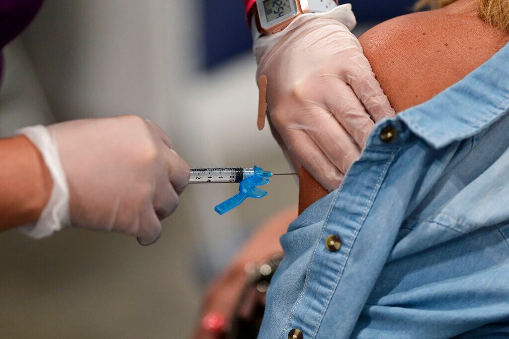 A health worker applies a Johnson and Johnson COVID-19 vaccine during a mass vaccination event carried out by the Department of Health and the Voces nonprofit organization, at the Miramar Convention Center in San Juan, Puerto Rico, Wednesday, March 31, 2021. (AP Photo/Carlos Giusti)