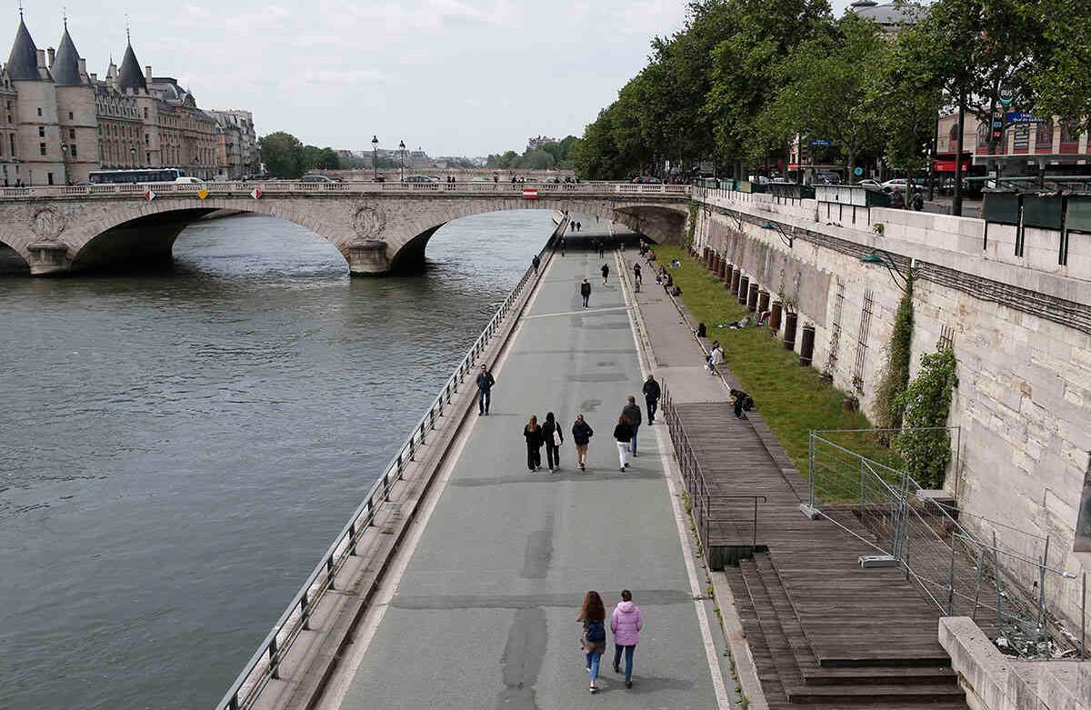Gente pasea a lo largo del río Sena el lunes 11 de mayo de 2020 en París. Tiendas de ropa, peluquerías y otros negocios grandes y pequeños reabrieron el lunes, con estrictas precauciones, para mantener a raya el coronavirus. Los franceses comenzaron a salir de sus casas y apartamentos por primera vez en dos meses cuando el país levantó cautelosamente su cuarentena. Foto: Rafael Yaghobzadeh/AP