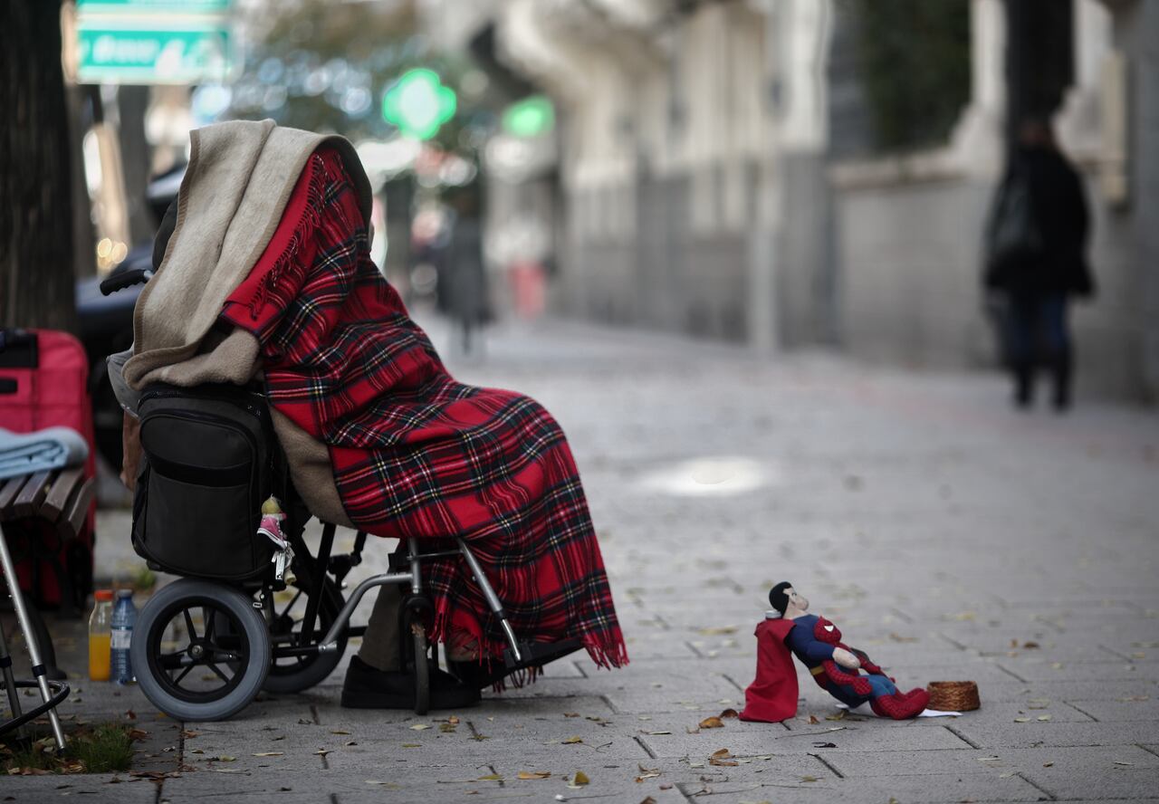 Una persona en silla de ruedas y tapada con una manta pide dinero con un muñeco de Superman en una céntrica calle durante la segunda ola de la pandemia del coronavirus, en Madrid (España), a 18 de noviembre de 2020.
18 NOVIEMBRE 2020;MENDIGO;SINTECHO;POBREZA;INCAPACIDAD
Eduardo Parra / Europa Press
  (Foto de ARCHIVO)
18/11/2020