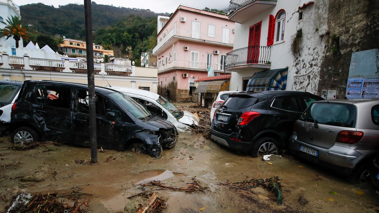 Se ven autos dañados en una carretera inundada después de que fuertes lluvias provocaran deslizamientos de tierra que colapsaron edificios y dejaron hasta 12 personas desaparecidas, en Casamicciola, en la isla de Ischia, en el sur de Italia, el sábado 26 de noviembre de 2022. Los bomberos están trabajando en los esfuerzos de rescate. ya que se envían refuerzos desde la cercana Nápoles, pero tienen dificultades para llegar a la isla en lancha o helicóptero debido al clima. (AP Photo/Salvatore Laporta)