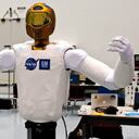 Embutido en un cuerpo de aluminio y bloques de espuma cortada a su medida, Robonaut 2, o R2, se prepara para dirigirse a la Estación Espacial Internacional dentro del Módulo Permanente multipropósito en la sección de carga útil del transbordador espacial Discovery como parte de la misión STS-133. Una vez en su lugar dentro de la estación, R2, con sus manos semejantes a las humanas y los brazos y la visión estéreo, tiene encomendadas llevar a cabo algunas de las funciones repetitivas o más rutinarias en el interior del laboratorio orbital, para dejar asi a los astronautas libres para otras tareas y experimentos. R2 fue diseñado por la NASA y General Motors.