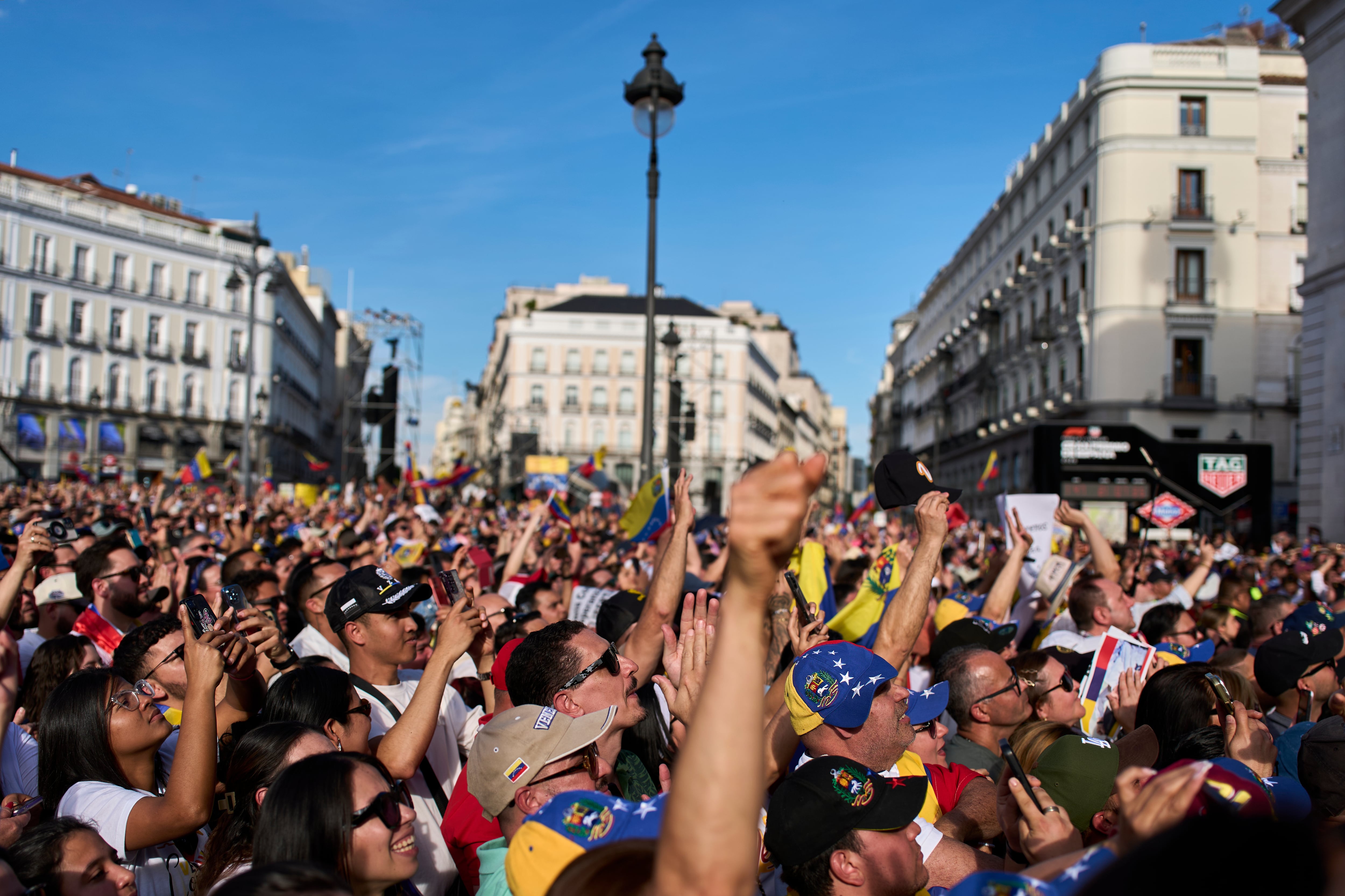 Simpatizantes venezolanos reaccionan mientras la líder de la oposición venezolana, María Corina Machado, pronuncia un discurso en la Puerta del Sol de Madrid, España.