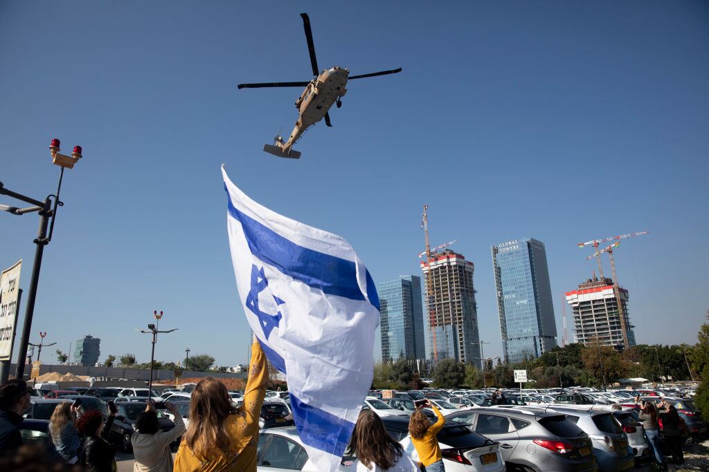 PETAH TIKVA, ISRAEL - JANUARY 30: A woman holds an Israeli flag as an army helicopter carrying newly released hostage Agam Berger is landing at Beilinson hospital on January 30, 2025 in Petah Tikva, Israel. Today was the third day on which hostages were released from Gaza under phase one of the Israel-Hamas ceasefire agreement. (Photo by Amir Levy/Getty Images)