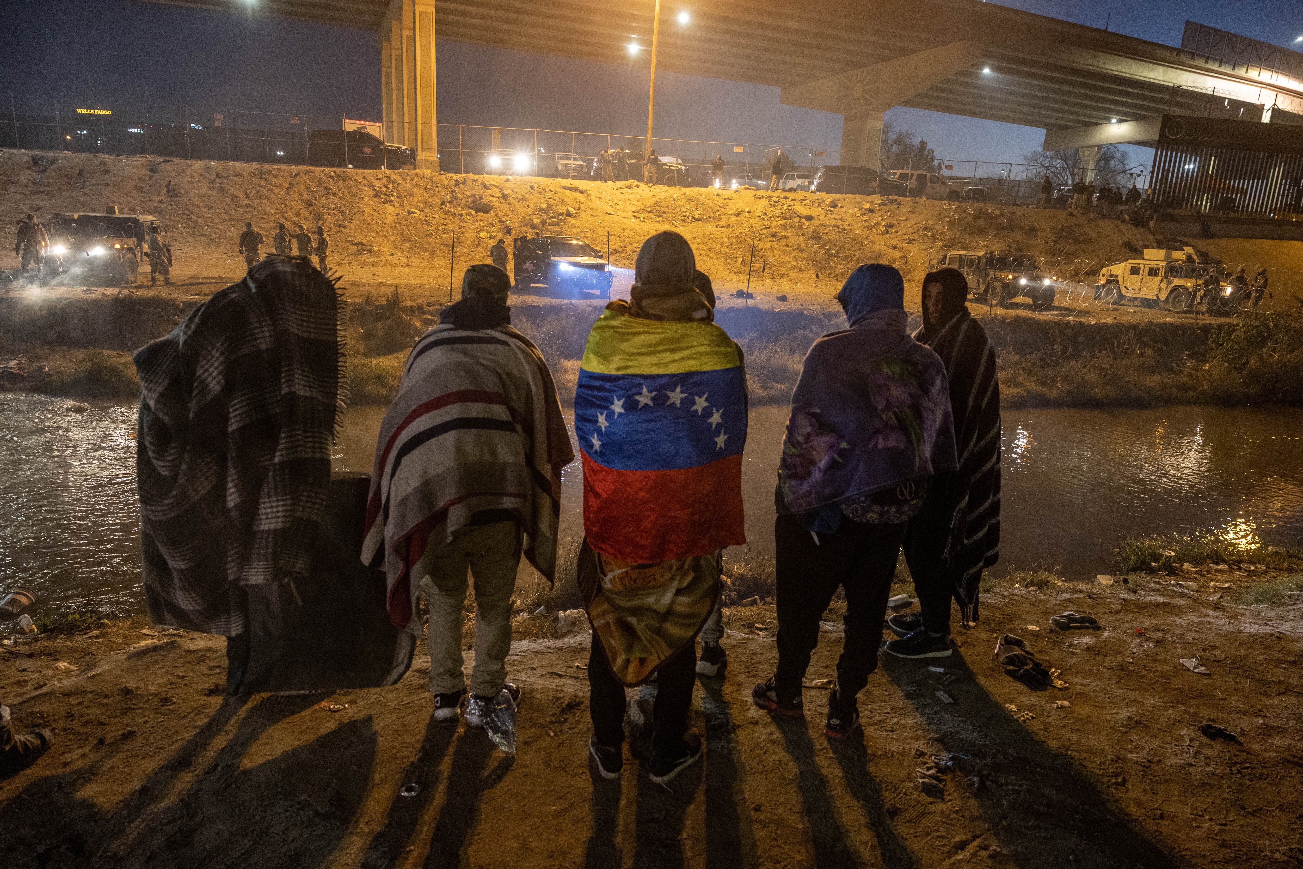 Tropas de la Guardia Nacional de Texas y la policía estatal impiden que los migrantes de Venezuela ingresen a una zona de cruce popular a lo largo de la orilla del Río Grande en El Paso, Texas, después de colocar alambre de concertina el 20 de diciembre de 2022, visto desde Ciudad Juárez, México.