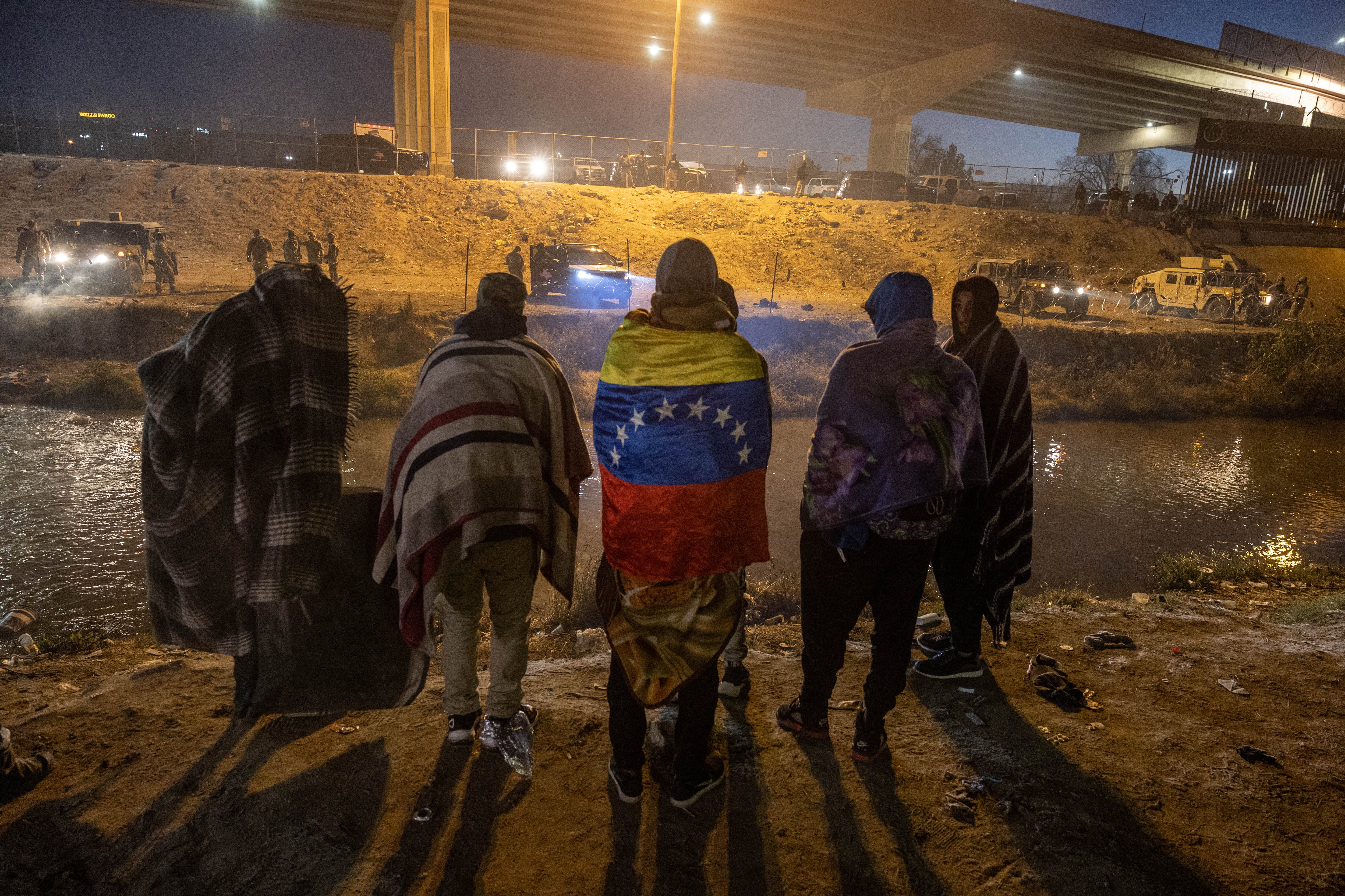 Tropas de la Guardia Nacional de Texas y la policía estatal impiden que los migrantes de Venezuela ingresen a una zona de cruce popular a lo largo de la orilla del Río Grande en El Paso, Texas, después de colocar alambre de concertina el 20 de diciembre de 2022, visto desde Ciudad Juárez, México.
