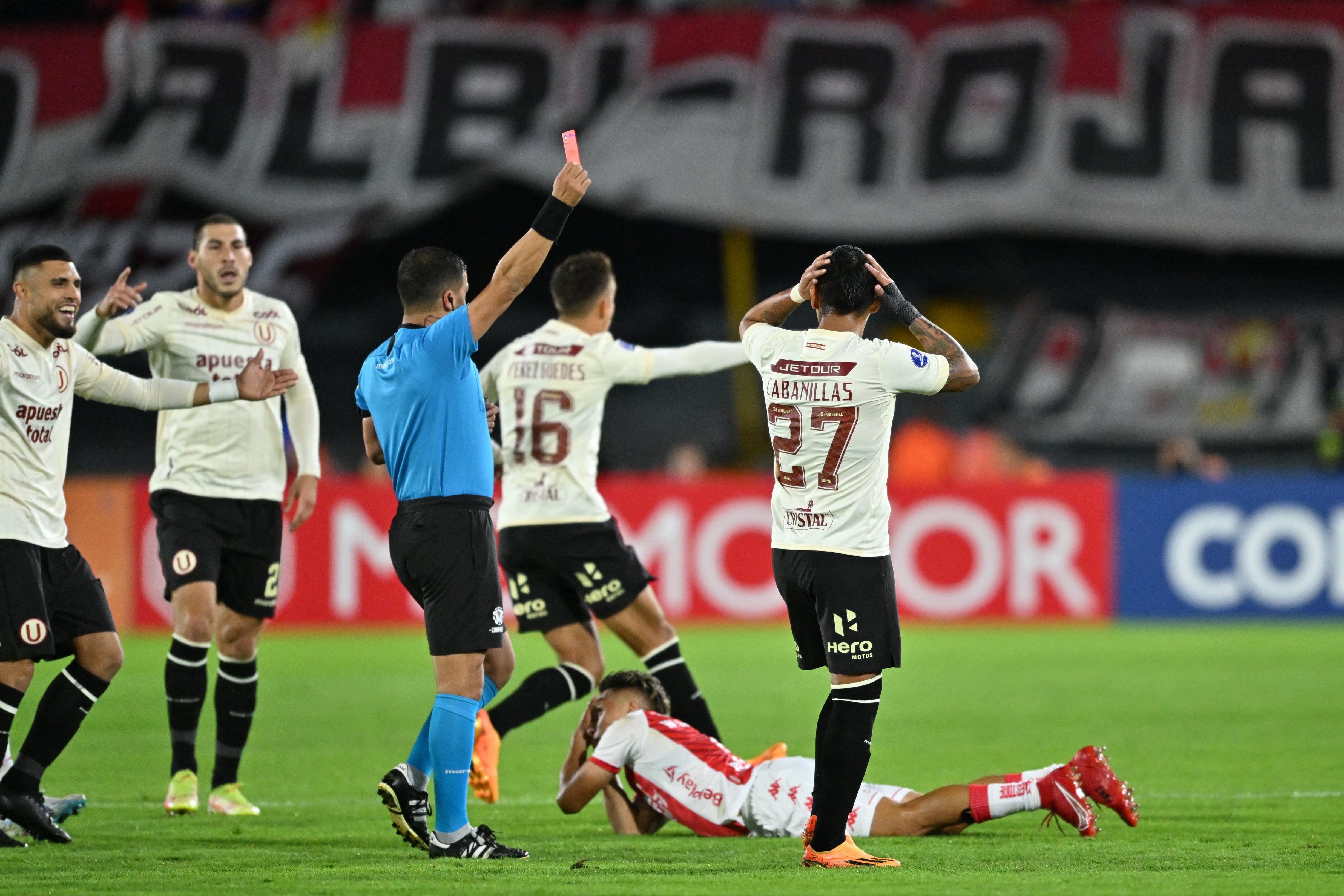 El árbitro chileno Felipe González muestra una tarjeta roja al defensor de Universitario Nelson Cabanillas durante el partido de vuelta de la fase de grupos de la Copa Sudamericana entre Independiente Santa Fe de Colombia y Universitario de Perú en el estadio Nemesio Camacho "El Campín" en Bogotá el 8 de junio de 2023.(Photo by Juan BARRETO / AFP)