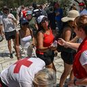 Los trabajadores de la Cruz Roja Helénica distribuyen botellas de agua a los visitantes fuera de la Acrópolis en Atenas el 13 de julio de 2023, mientras Grecia alcanza altas temperaturas. Foto: AFP