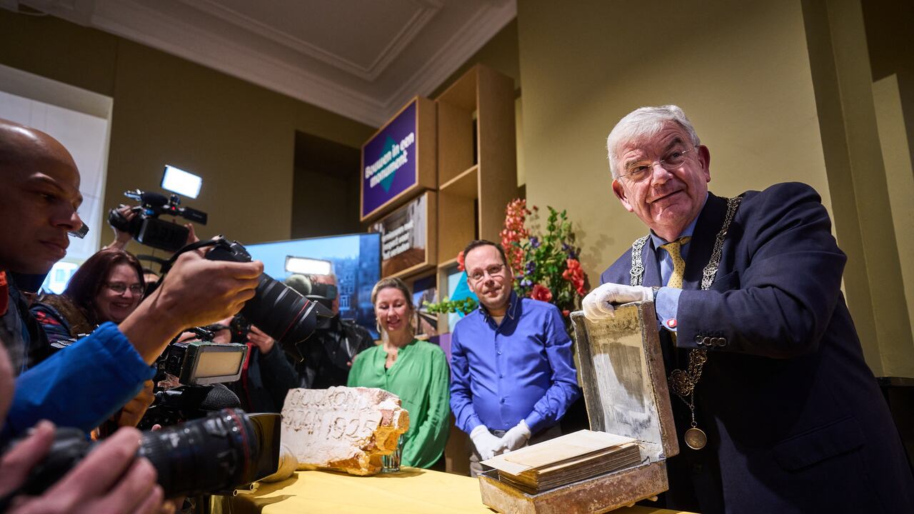 El alcalde de La Haya, Jan van Zanen (derecha), abre una cápsula del tiempo encontrada bajo el pedestal de la estatua ecuestre del rey Guillermo II en La Haya, el 29 de enero de 2024. La cápsula fue encontrada en Hofvijver durante unas obras de renovación.