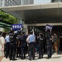 TOPSHOT - Police officers look at people gathering at the Evergrande headquarters in Shenzhen, southeastern China on September 16, 2021, as the Chinese property giant said it is facing "unprecedented difficulties" but denied rumours that it is about to go under. (Photo by Noel Celis / AFP)