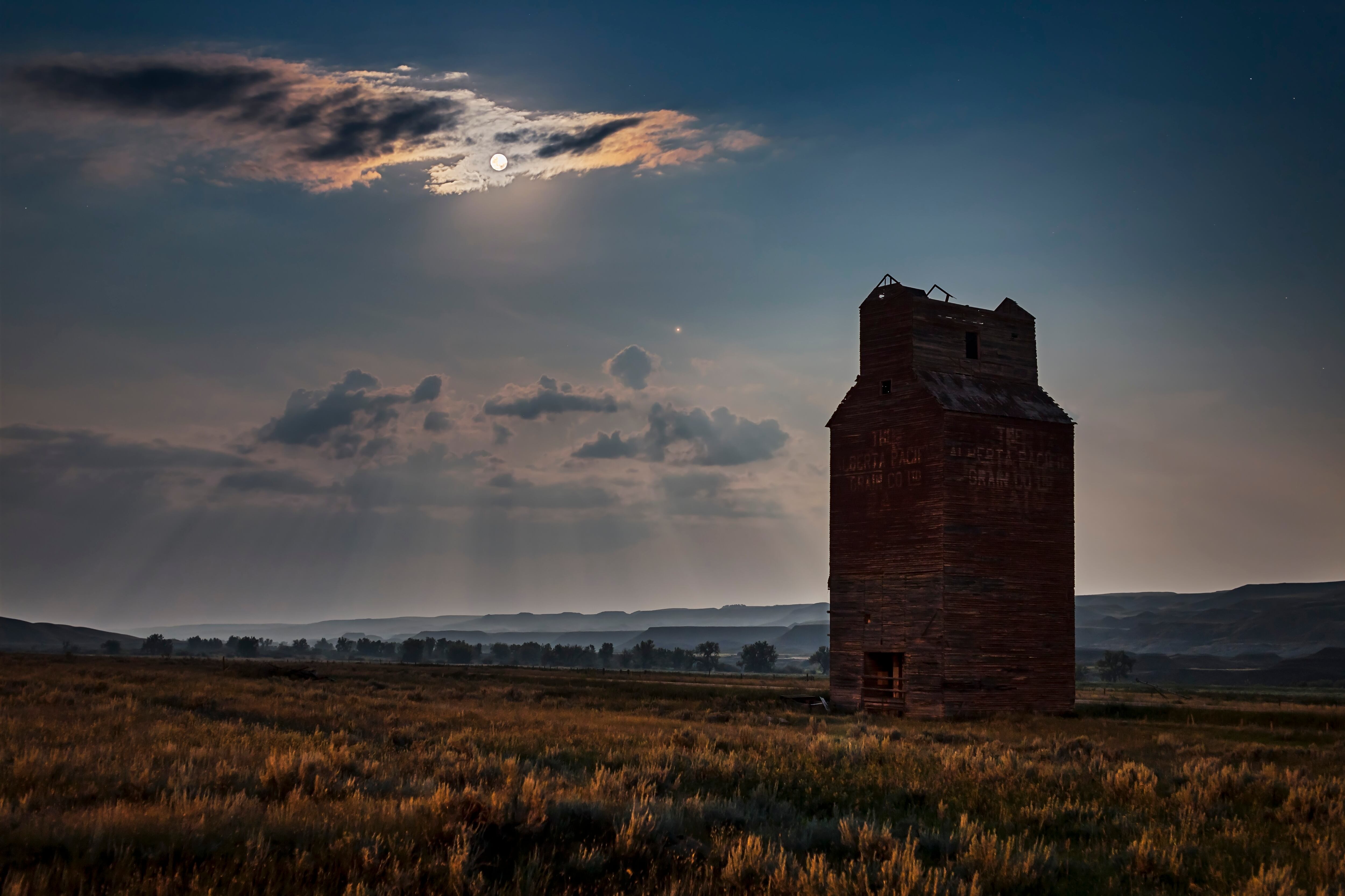 La Luna Llena y Marte elevándose hacia el sureste sobre el elevador de granos abandonado en Dorothy, Alberta, en el valle del río Red Deer, Alberta. Esto fue el 27 de julio de 2018