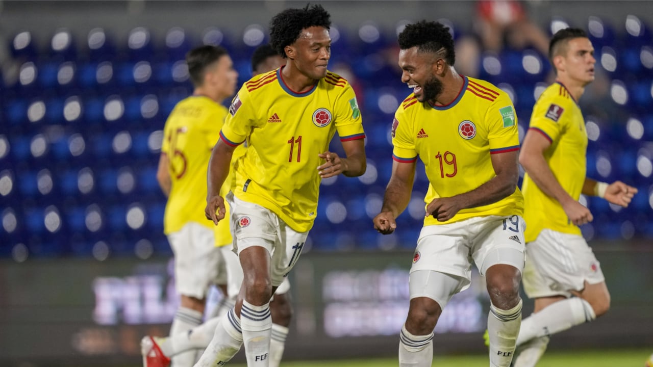 Colombia's Juan Cuadrad, left, celebrates with teammate Miguel Borja after scoring from the penalty spot his side's opening goal against Paraguay during a qualifying soccer match for the FIFA World Cup Qatar 2022 in Asuncion, Paraguay, Sunday, Sept. 5, 2021. (AP Photo/Jorge Saenz)