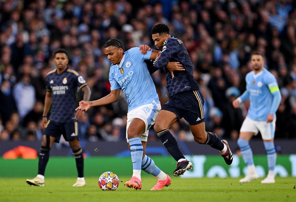 MANCHESTER, ENGLAND - APRIL 17: Manuel Akanji of Manchester City is challenged by Jude Bellingham of Real Madrid during the UEFA Champions League quarter-final second leg match between Manchester City and Real Madrid CF at Etihad Stadium on April 17, 2024 in Manchester, England. (Photo by Stu Forster/Getty Images)