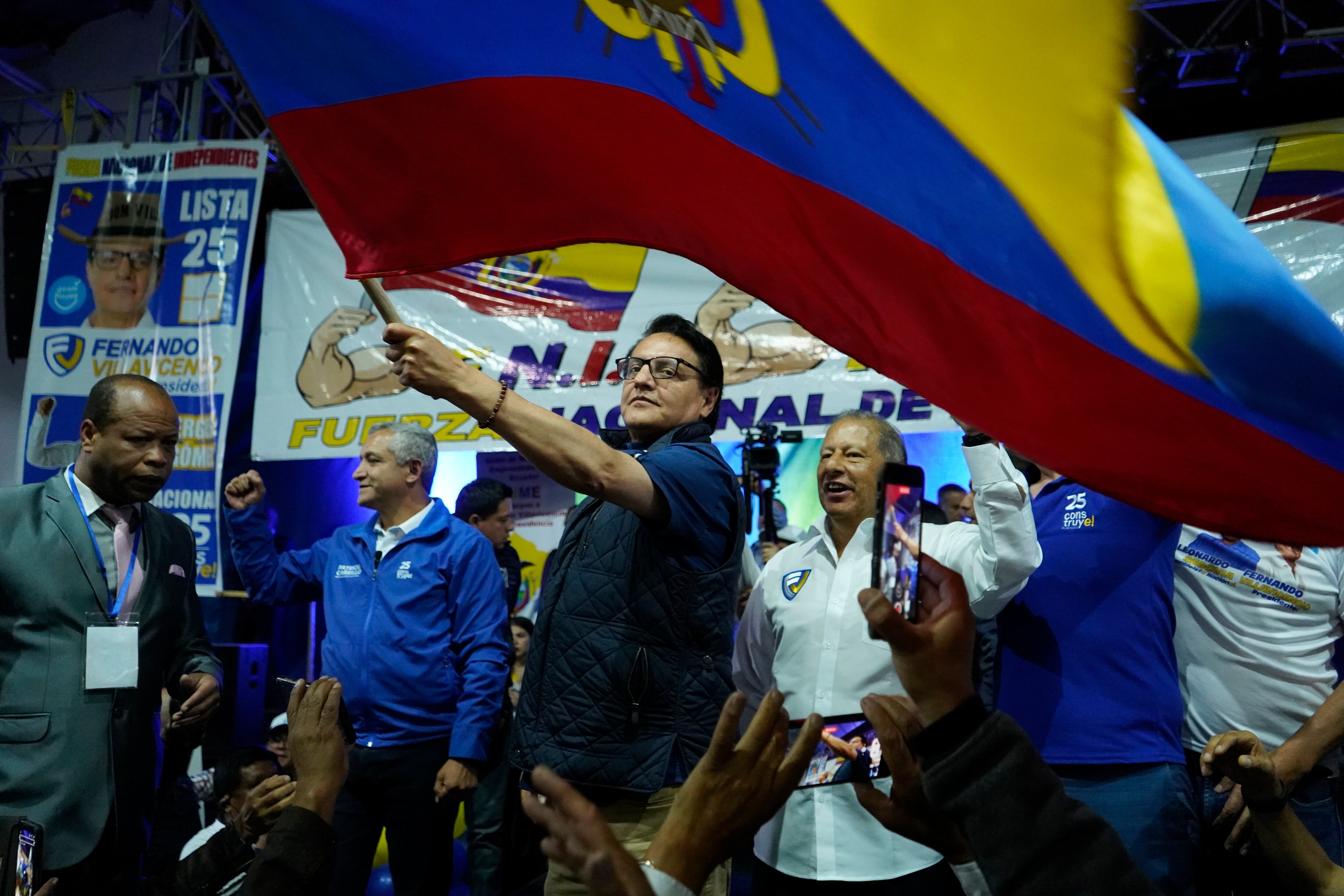El candidato presidencial Fernando Villavicencio ondea una bandera nacional durante un evento de campaña en una escuela minutos antes de que lo mataran a tiros en Quito, Ecuador, el 9 de agosto de 2023. (AP vía AP/Archivo)