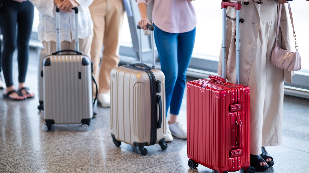 Turistas esperando en el aeropuerto con sus maletas