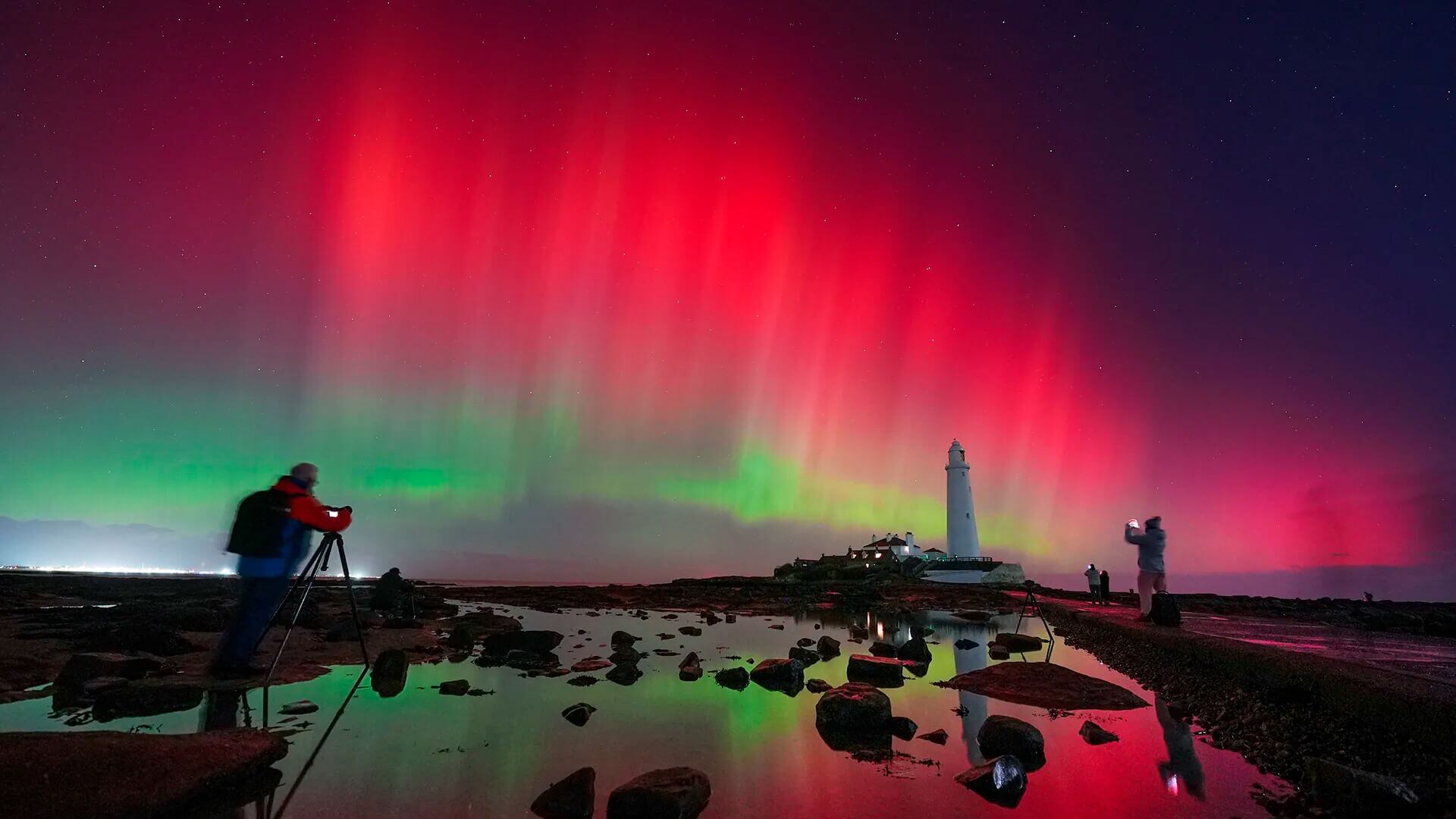 La aurora boreal ilumina el cielo sobre el faro de Santa María, en la bahía de Whitley, costa noreste de Inglaterra, el miércoles 12 de noviembre de 2025.